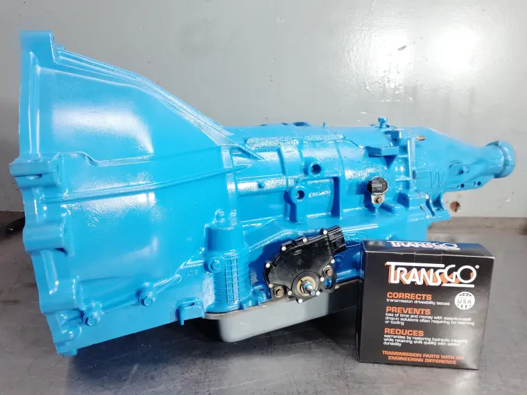 Transmisión reconstruida con acabado azul claro junto a un kit de reprogramación TransGo